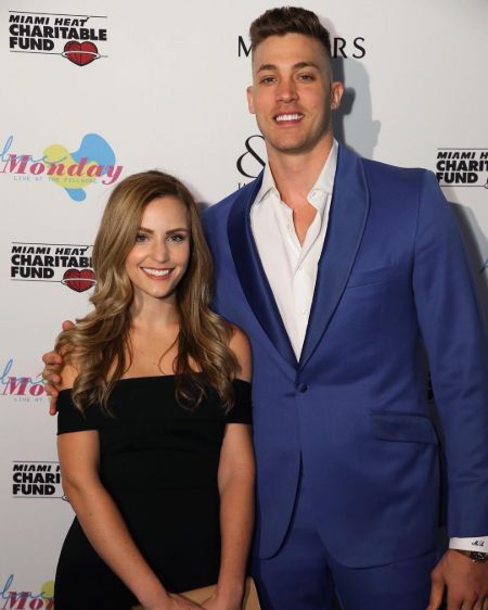 Miami Heats star Meyers Leonard in a blue suit poses a phoot with wife Elle Leonard.
